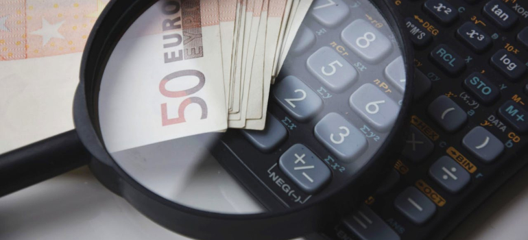 Digitron, lupa i novčanice na beloj površini