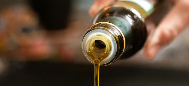 Osoba koja koristi maslinovo ulje za spremanje hrane 