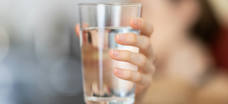 Osoba koja drži čašu vode 