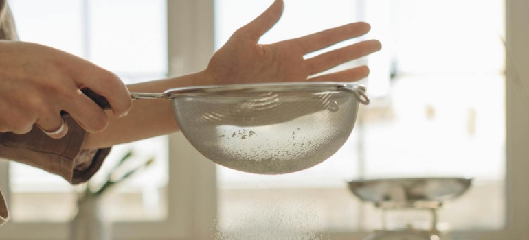 Osoba koja stavlja brašno u posudu 