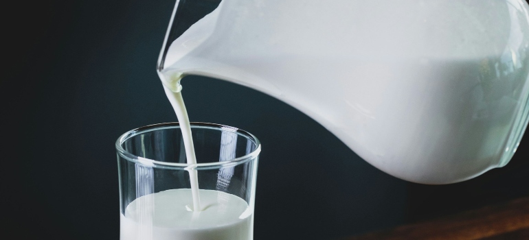 Osoba koja sipa kefir u čašu