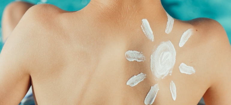 Osoba sa kremom za sunčanje na leđima