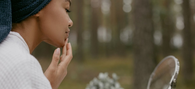 Osoba koja nanosi kremu na lice 