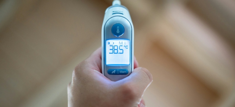 Osoba koja drži digitalni toplomer